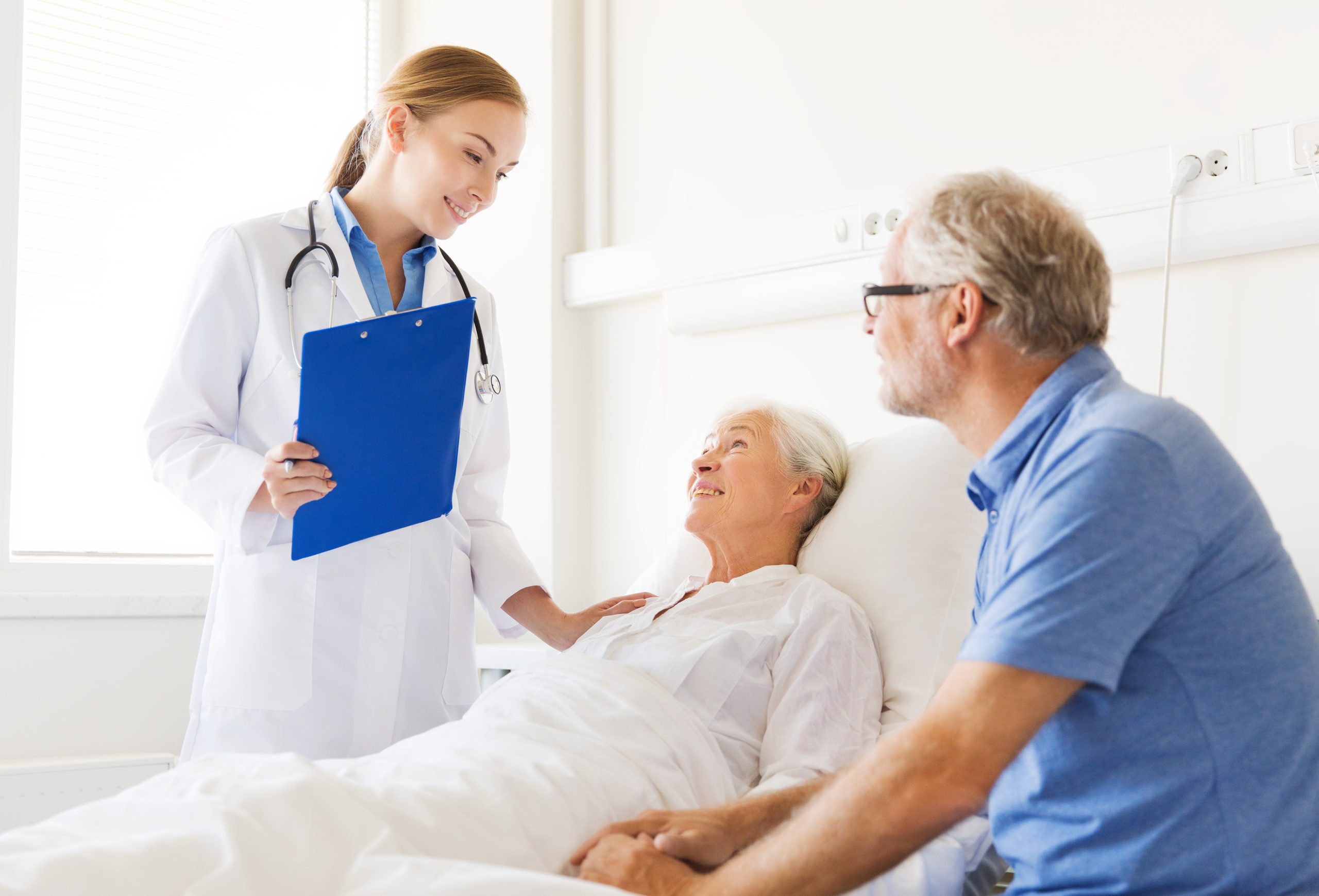 medicine, age, health care and people concept - senior woman, man and doctor with clipboard at hospital ward